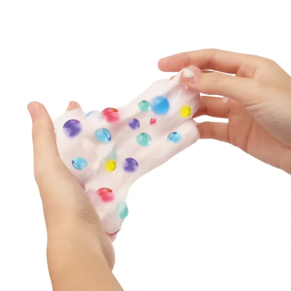 Händer som sträcker genomskinligt Bubble Slime fyllt med färgglada pärlor.
