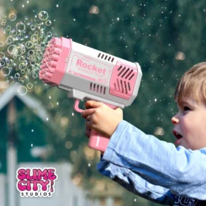 Barn som använder en rosa bubbelpistol bazooka och skapar massor av bubblor.