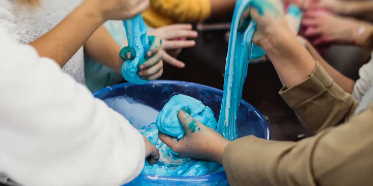 Barn leker med blått slime på kalas