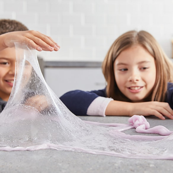 Två barn leker med elastiskt slime skapat med Elmer's slime glue