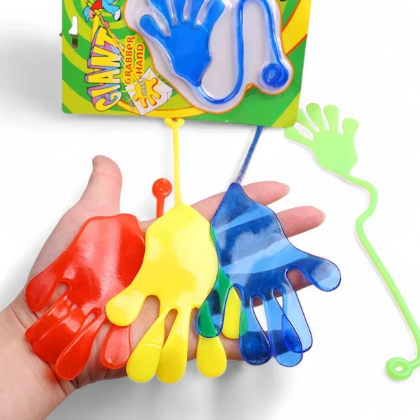 Stor slimehand klibbig leksak i röd, gul, blå och grön färg hållna i hand