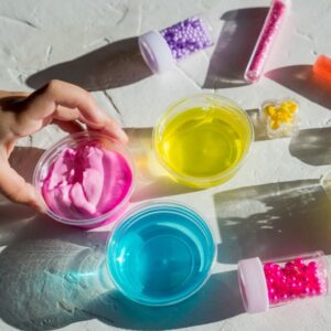 Pyssel med slime och färgglada tillbehör – rosa, gul och blå slime.