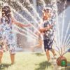 Barn leker i trädgården med snigel vattenspridare med spridande slangar – perfekt vattenlek utomhus på sommaren